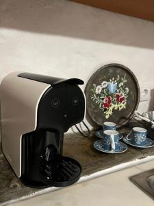 una cafetera negra sentada en un mostrador junto a las tazas en A Casa do Mestre Lau - no coração do Alentejo, en Terena