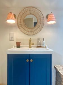een badkamer met een blauwe wastafel en een spiegel bij The Pool House in Henley on Thames