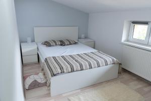 a white bedroom with a bed and two night stands at Apartament - Bystra in Bystra
