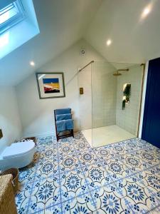 een badkamer met een douche en een blauwe stoel bij The Pool House in Henley on Thames