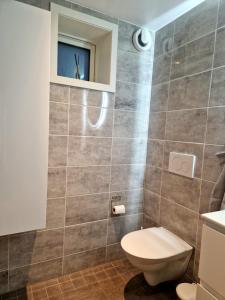 a bathroom with a toilet and a window at R apartment in Kungsängen in Kungsängen