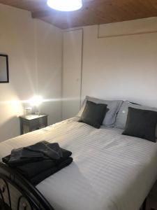 una camera da letto con un grande letto bianco con cuscini neri di Alpha house a Londra