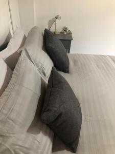 a white couch with three pillows on it at Alpha house in London