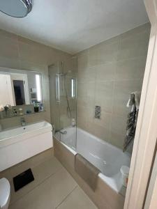 La salle de bains est pourvue d'une baignoire, d'une douche et d'un lavabo. dans l'établissement Refurbished central apartment, à Londres