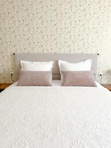 a bedroom with a white bed with two pillows at Margate Accommodation in Haapsalu