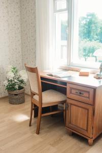 a wooden desk with a chair and a window at Margate Accommodation in Haapsalu