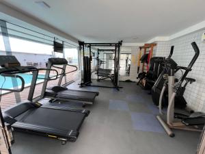 a gym with several treadmills and exercise bikes in it at Seu lugar em Natal in Natal