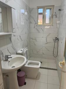 a white bathroom with a sink and a toilet at Kleida Vacation Apartments in Spille +28 photos