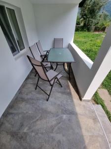 een patio met 2 stoelen, een tafel en een raam bij Green Nest in Brezoi