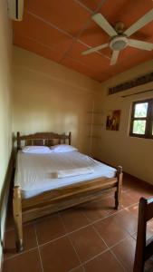 a bedroom with a bed with a ceiling fan at Hostal Casa Bonita Ometepe in Rivas