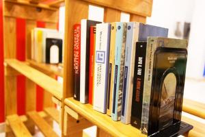 una fila di libri seduti su uno scaffale di Hotel Byron solo per giovani a Riccione
