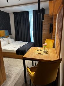 a bedroom with a bed and a table and chairs at Dana Apartmani in Kopaonik