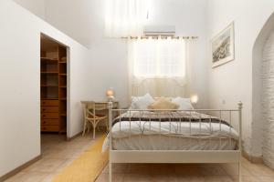 a bedroom with a bed and a window and a table at הסמטה של יפו in Tel Aviv