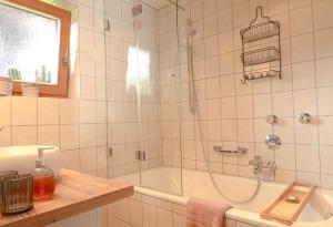 a bathroom with a shower and a tub and a sink at Engelsherz in Mittenwald