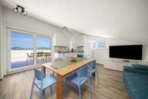 a kitchen and dining room with a table and chairs at Apartments Picikato in Bilice
