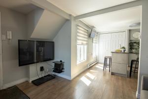 a living room with a large flat screen tv on a wall at Condo in St-Roch Downtown Quebec City in Quebec City +20 photos