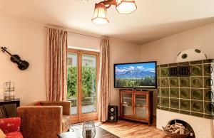 sala de estar con TV y chimenea en Engelsherz, en Mittenwald