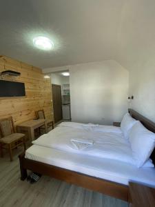 a bedroom with a large bed with white sheets at Apartmani Srećko in Žabljak