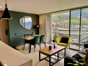 ein Wohnzimmer mit einem Sofa, einem Tisch und Stühlen in der Unterkunft Apartamento el poblado cerca a Provenza in Medellín