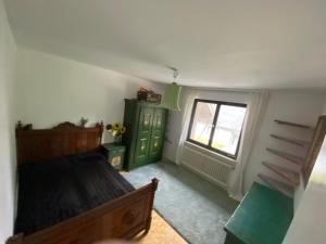 a bedroom with a bed and a green cabinet and a window at Natur Pur im Hochschwarzwald in Herrenschwand