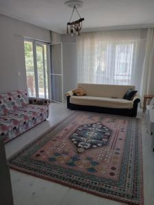 uma sala de estar com um sofá e um tapete em Luwigayrimenkul em Gokceada Town