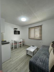 a bedroom with a bed and a table and a kitchen at Apartmani Srećko in Žabljak