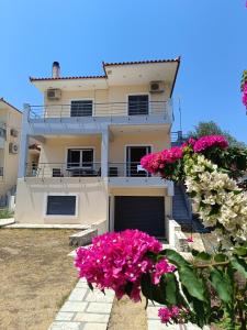 卡托阿米里的住宿－Villa Maria，前面有粉红色花的房子