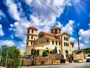a large building with two towers on top of it at Ble Residence, Your Home Away from Home in Panormos Rethymno
