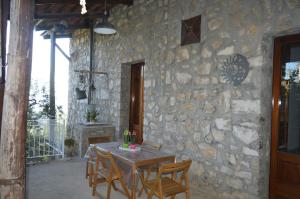 einen Tisch und Stühle vor einer Steinmauer in der Unterkunft La Petra in Vico Equense