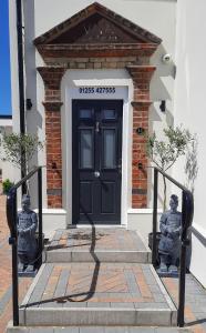 a black door with two statues in front of a building at Viva Guest House in Clacton-on-Sea