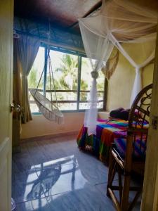 1 dormitorio con hamaca en una habitación con ventana en Casa Lilo Mahahual - privat house en Mahahual