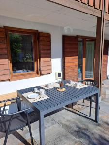 un tavolo blu e sedie seduti su un patio di Appartamento con terrazza di mq 40 con vista Pale di San Martino a San Martino di Castrozza