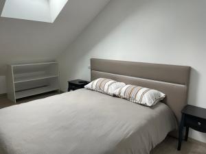 een slaapkamer met een wit bed en 2 nachtkastjes bij Appartement centre ville - Sablé sur Sarthe in Sablé-sur-Sarthe