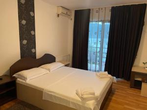 a bedroom with a bed with white sheets and a window at Casa Darian in Dubova +40 photos