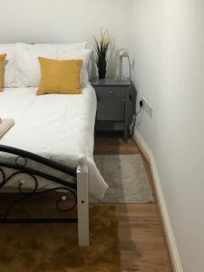 a bedroom with a bed with a yellow pillow on it at Alpha house in London