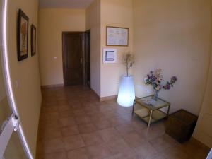 a hallway with a table and a vase of flowers at Hostal Rte. Casa Miguel in Matalascañas