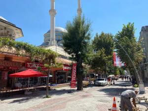 a man is walking down a street with a mosque at Apartment in Buyukcekmece