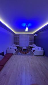 uma grande sala de estar com sofás e um tecto azul em Apartment em Büyükçekmece