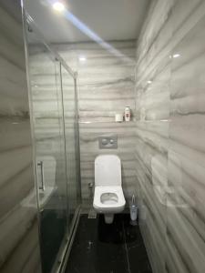 a bathroom with a toilet and a glass shower at Apartment in Buyukcekmece