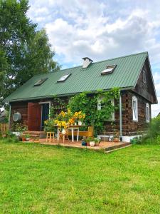 een klein huis met een groen dak en een tuin bij Magiczne Podlasie 