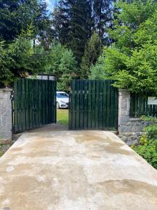 a gate in a driveway with a car behind it at Cabana Miska Chalet in Miercurea-Ciuc