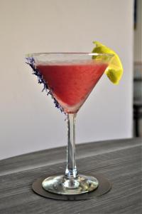una bevanda rossa in un bicchiere di Martini con lime di Hotel Costa Azzurra a Briatico
