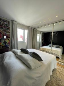 a bedroom with a large white bed with mirrors at Studio Deluxe - Dot 173 in Campinas