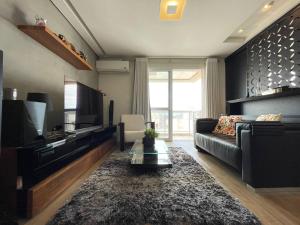 a living room with a couch and a tv at Studio Deluxe - Dot 173 in Campinas