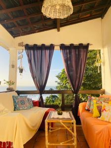 a living room with a couch and a window at Vista Surf Pipa Hostel in Pipa