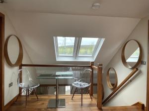 2 sillas y una mesa de cristal en una habitación con espejos en Waterfront House, en Finstown