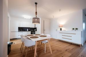 - une cuisine blanche avec une table et des chaises blanches dans l'établissement Nordlicht Oase I modern + ruhig, à Hanovre