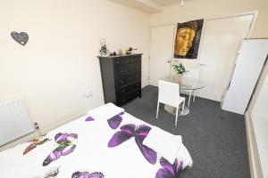 een slaapkamer met een bed en een tafel bij Jah lodge in Croydon