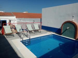 a swimming pool on a balcony with chairs around it at Alentejo Cante & Vinho in Ferreira do Alentejo