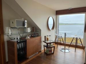 a living room with a tv and a table with chairs at Waterfront House in Finstown